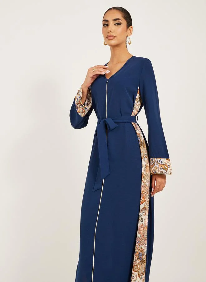 Styli navy olive colour jalabiya w/ navy blue pailsey print inserts at sides and slv cuff w/ gold cord trim at CF and sleeve hem