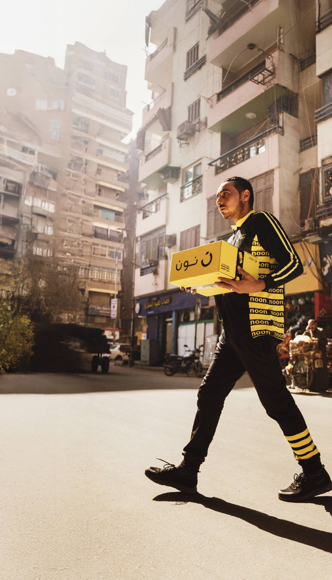 A noon delivery agent carrying a box for delivery in Dubai