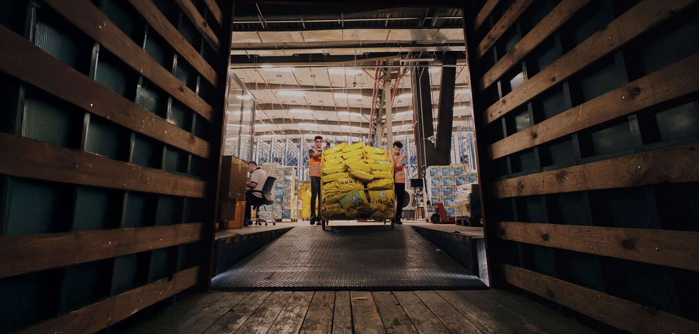 noon Employees loading packages into shipping crate